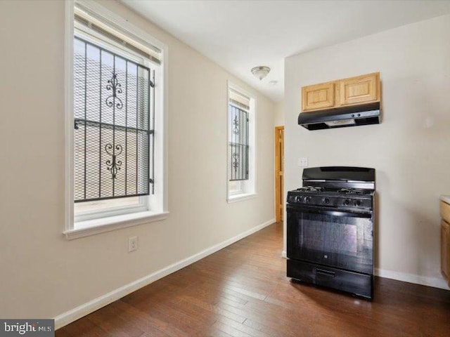 kitchen featuring light brown cabinets, black range with gas stovetop, a healthy amount of sunlight, and dark hardwood / wood-style floors