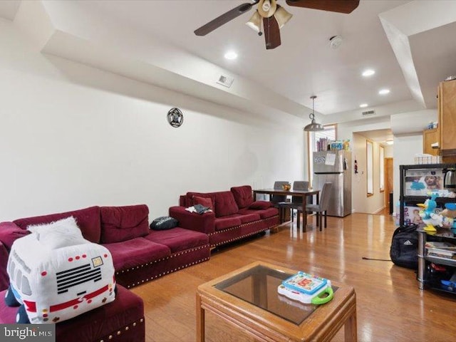 living room featuring light hardwood / wood-style flooring and ceiling fan