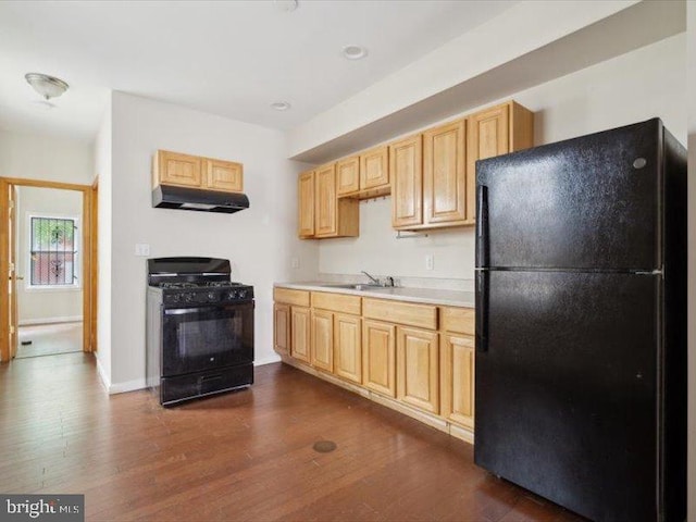 kitchen with dark wood-type flooring, light brown cabinets, black appliances, and exhaust hood