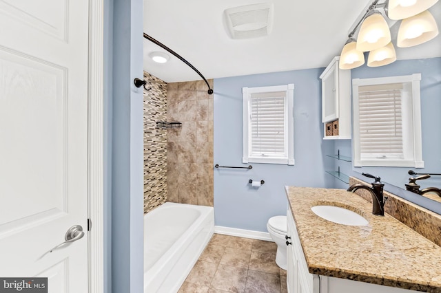 full bathroom with vanity, tiled shower / bath combo, toilet, and tile patterned flooring