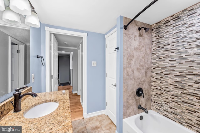 bathroom featuring tile patterned floors, tiled shower / bath combo, and vanity