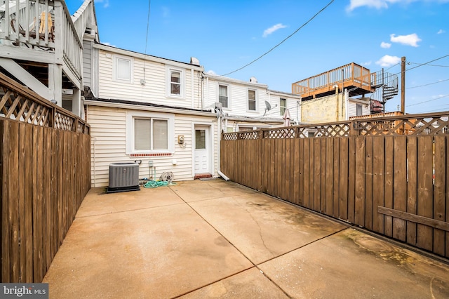 back of property with cooling unit and a patio