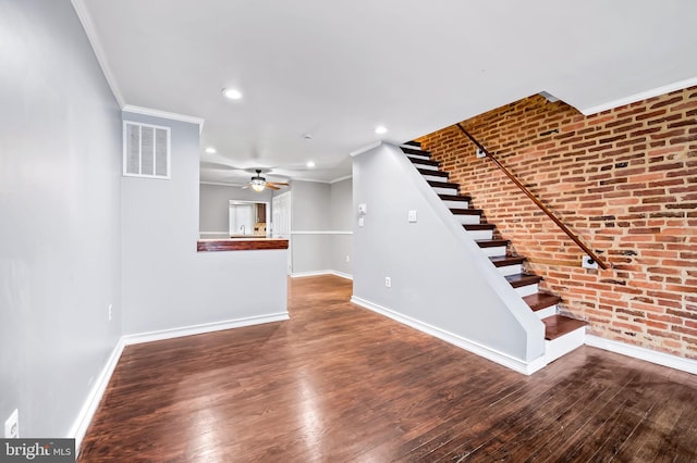 interior space featuring crown molding, ceiling fan, brick wall, and hardwood / wood-style flooring