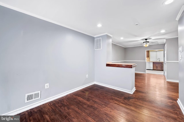 unfurnished living room with sink, ornamental molding, and hardwood / wood-style flooring