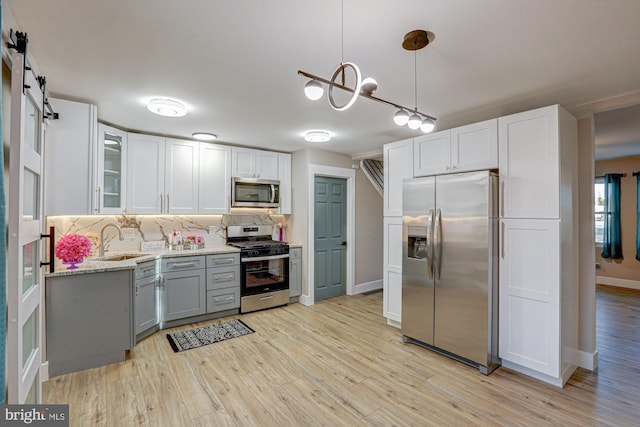 kitchen with decorative backsplash, white cabinetry, appliances with stainless steel finishes, and sink