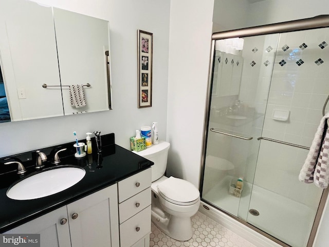 bathroom featuring vanity, an enclosed shower, and toilet