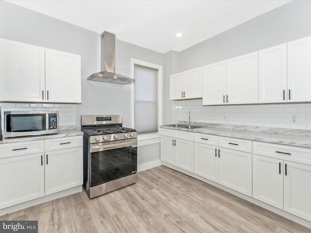 kitchen featuring white cabinets, sink, wall chimney exhaust hood, and stainless steel appliances