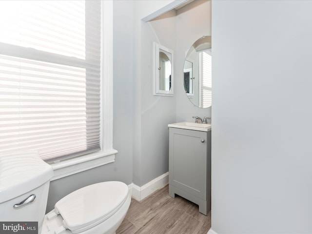 bathroom with wood-type flooring, toilet, and vanity