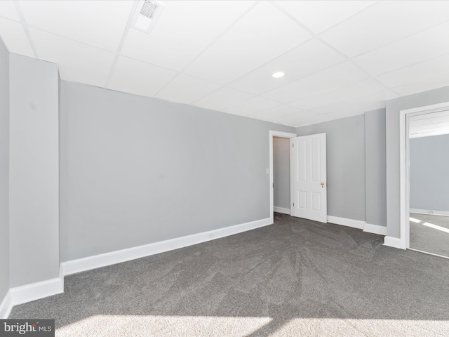 carpeted spare room featuring a paneled ceiling