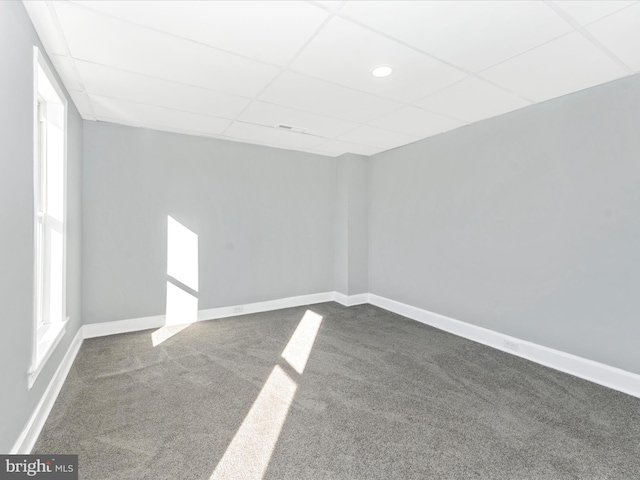 carpeted empty room featuring a paneled ceiling