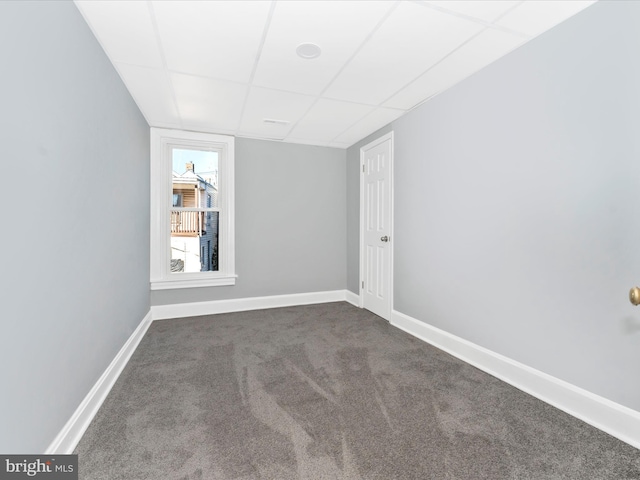 carpeted empty room with a paneled ceiling