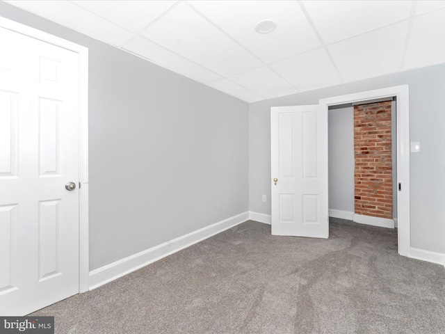 unfurnished bedroom with a drop ceiling and carpet