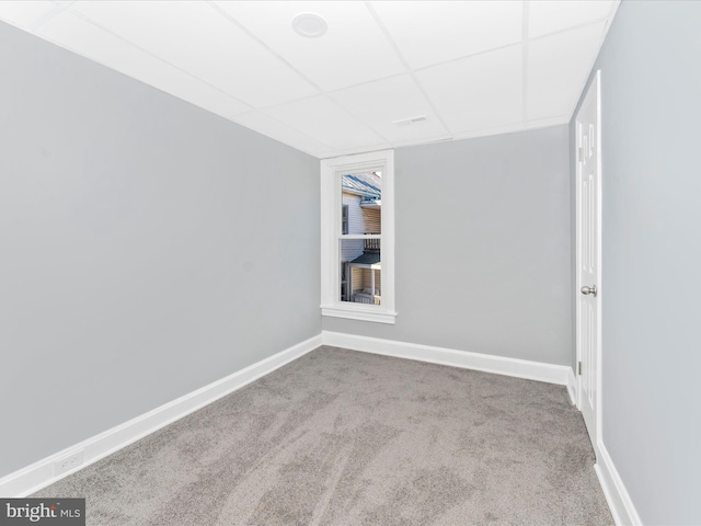 spare room with carpet flooring and a drop ceiling