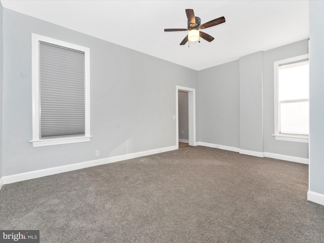 empty room with ceiling fan and carpet floors