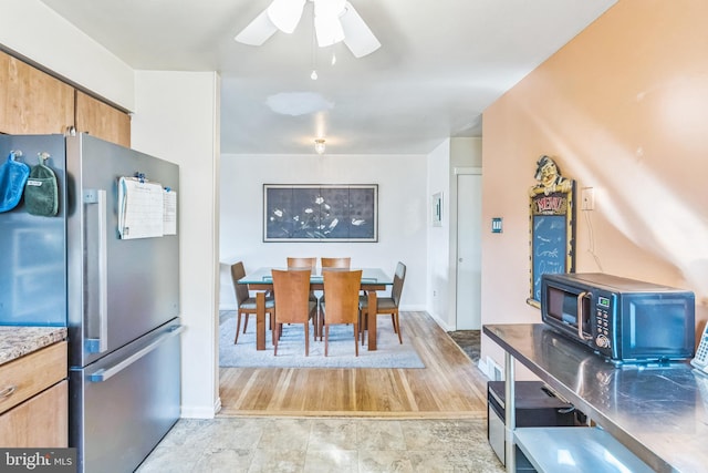 kitchen featuring ceiling fan, stainless steel fridge, and light hardwood / wood-style flooring