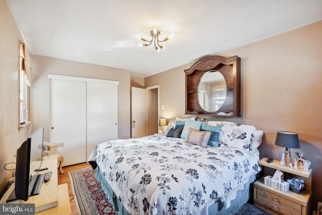 bedroom with a chandelier, a closet, and hardwood / wood-style floors