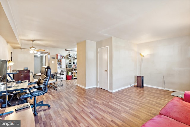 home office with light wood-type flooring and ceiling fan