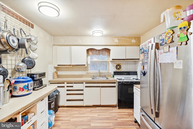 kitchen with white cabinets, decorative backsplash, light wood-type flooring, white range oven, and stainless steel refrigerator