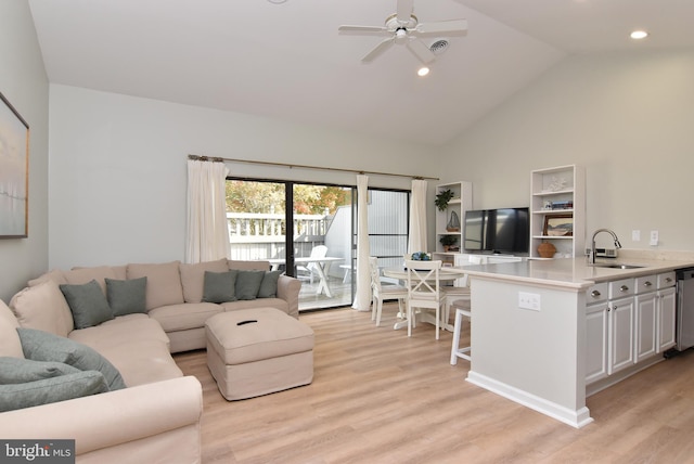 living room with high vaulted ceiling, light hardwood / wood-style floors, sink, and ceiling fan