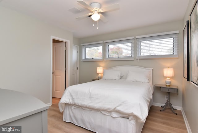 bedroom with light hardwood / wood-style floors, multiple windows, and ceiling fan