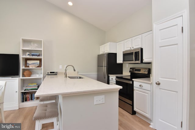 kitchen featuring white cabinetry, appliances with stainless steel finishes, sink, and lofted ceiling