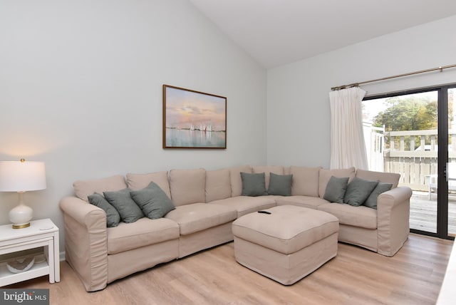 living room with light hardwood / wood-style flooring and high vaulted ceiling