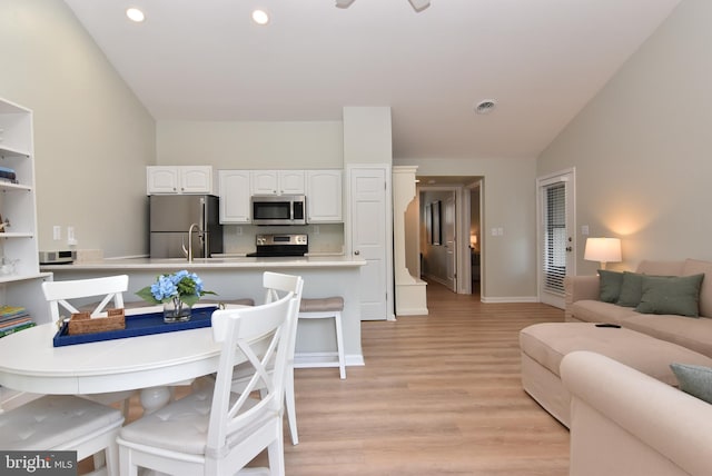 interior space featuring light hardwood / wood-style flooring, lofted ceiling, and sink