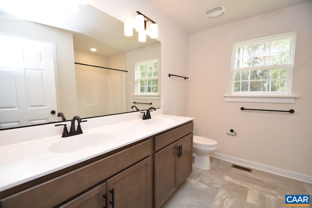 bathroom with walk in shower, vanity, and toilet