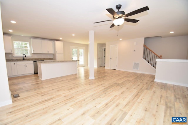 unfurnished living room featuring ceiling fan, sink, and light hardwood / wood-style flooring