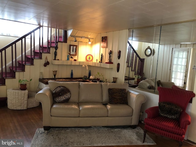 living room with hardwood / wood-style floors and wood walls