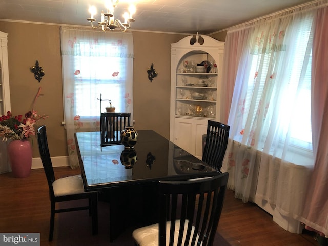 dining room with dark hardwood / wood-style floors, crown molding, and a notable chandelier