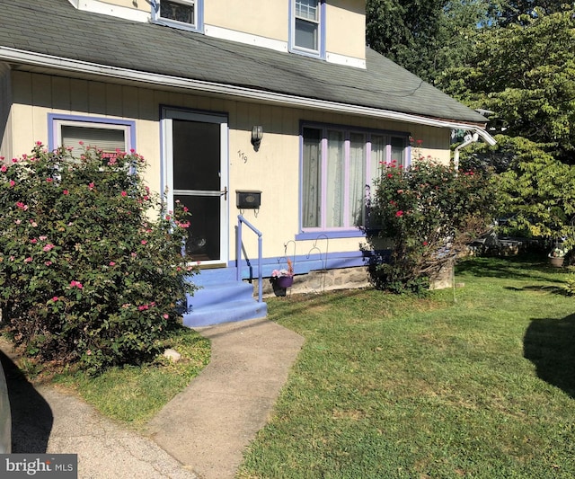 view of exterior entry with a yard