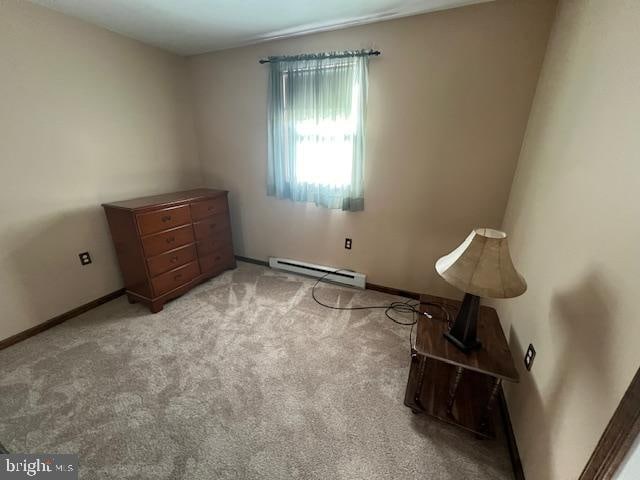 living area featuring light carpet and a baseboard radiator