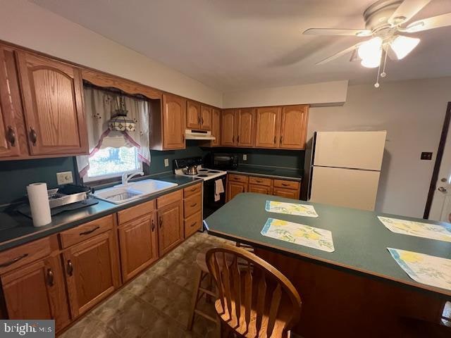 kitchen featuring white appliances, ceiling fan, and sink