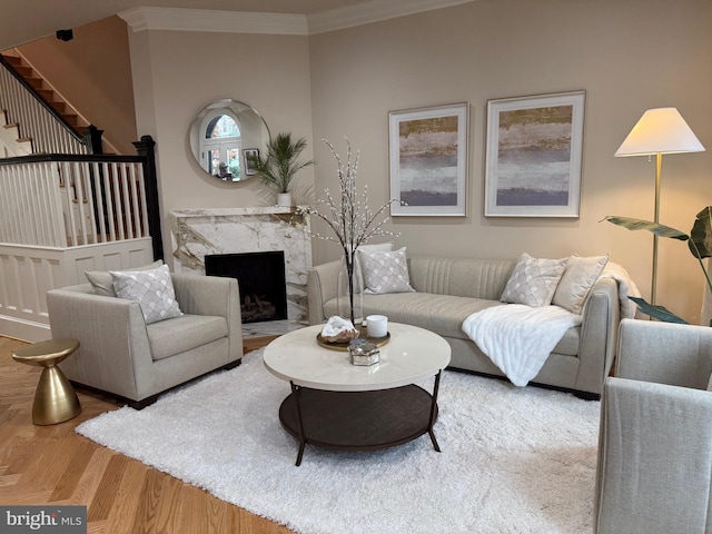 living room featuring crown molding, a high end fireplace, and hardwood / wood-style flooring