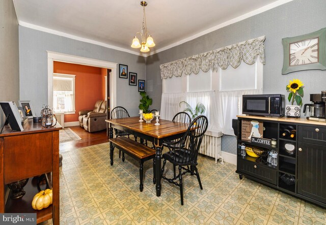 dining room featuring hardwood / wood-style floors, a chandelier, and crown molding