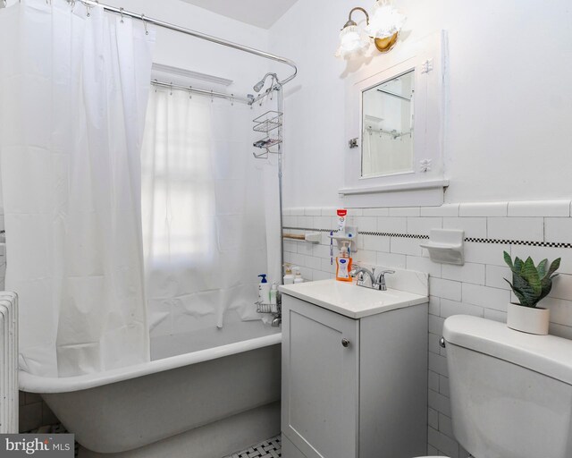 full bathroom featuring toilet, vanity, tile walls, and shower / bathtub combination with curtain