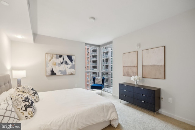 bedroom with floor to ceiling windows and light carpet