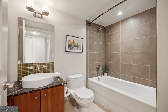 full bathroom with tiled shower / bath combo, tasteful backsplash, vanity, tile patterned floors, and toilet