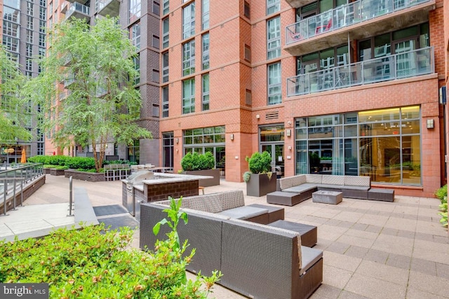 exterior space featuring a patio and an outdoor living space with a fire pit