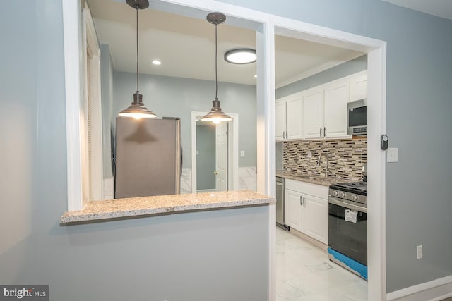 kitchen with white cabinets, decorative backsplash, kitchen peninsula, and appliances with stainless steel finishes