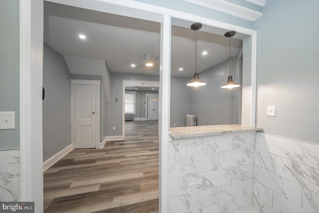 kitchen with pendant lighting, hardwood / wood-style flooring, and radiator