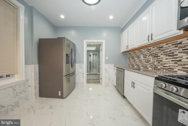 kitchen featuring stainless steel appliances, white cabinetry, and sink