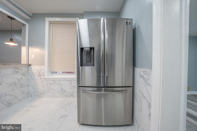 kitchen with hanging light fixtures and stainless steel refrigerator with ice dispenser