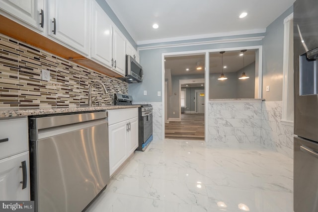 kitchen featuring light stone countertops, light hardwood / wood-style flooring, decorative light fixtures, white cabinets, and appliances with stainless steel finishes