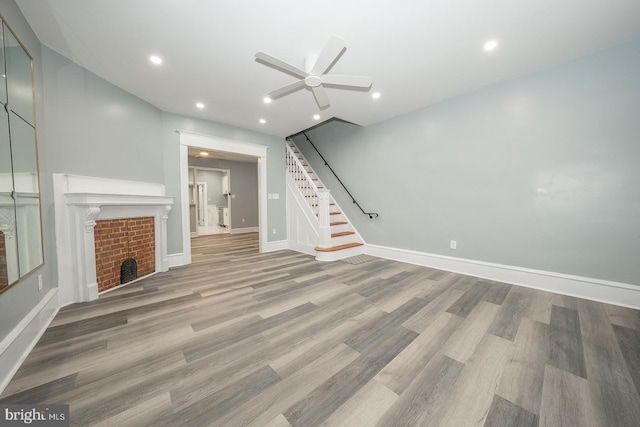 unfurnished living room featuring ceiling fan and hardwood / wood-style flooring