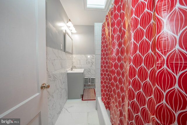 bathroom featuring shower / tub combo, vanity, and tile walls