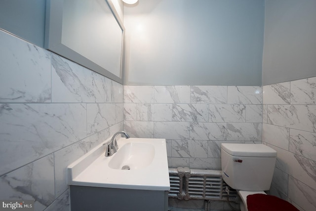 bathroom with vanity, tile walls, and toilet