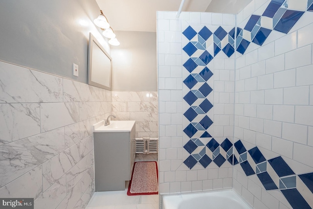 bathroom featuring vanity, tile walls, and a tub