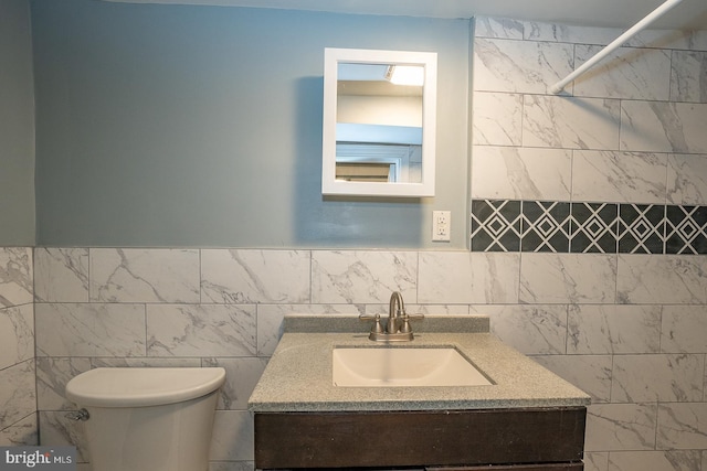 bathroom featuring vanity, a shower, toilet, and tile walls